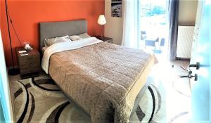 a bedroom with a bed with an orange wall at Demetras' house in Nafplio