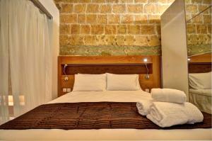 ein Schlafzimmer mit einem Bett mit Handtüchern darauf in der Unterkunft Coral Apartment (Valletta) in Valletta