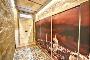einen Flur mit einem Gemälde an der Wand und einer Tür in der Unterkunft Coral Apartment (Valletta) in Valletta