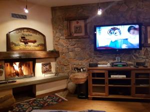 a living room with a fireplace and a flat screen tv at Casadolcino in Campodolcino