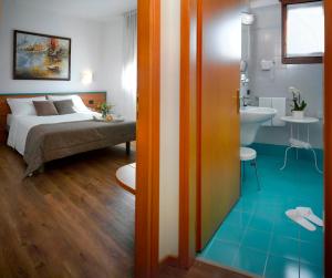 a bedroom with a bed and a bathroom with a sink at Hotel Eurorest in Conegliano