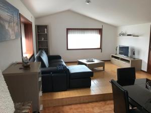a living room with a couch and a table at Casa Ferreira in Vila Chã