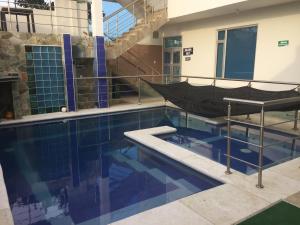 a swimming pool with a hammock in a building at Palmarito Beach Apartamentos in Carretal