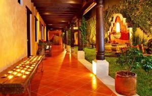 a hallway of a building with a bench and plants at Hotel Meson del Valle by AHS in Antigua Guatemala