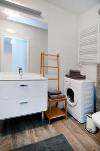 a bathroom with a sink and a washing machine at AquaBaltic in Kołobrzeg