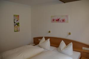 a bedroom with two beds and two pictures on the wall at Decker's Bio Hotel zum Lamm in Baiersbronn