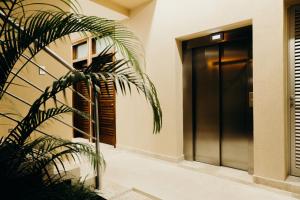 a door to a building with a palm tree next to it at Biwa Tulum in Tulum