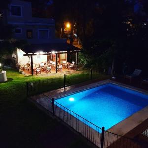 a swimming pool with a fence around it at night at El Cortijo in Pinamar
