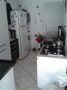 a kitchen with a stove and a white refrigerator at Hospedagem da Grega in Balneário Camboriú