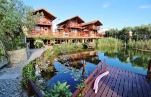 uma grande casa de madeira com um lago em frente em Villa Ana Margarida by Nature na Ericeira