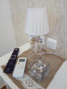 een lamp op een tafel met een afstandsbediening en een afstandsbediening bij Apartment "Happiness" near metro and center in Athene
