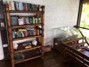a book shelf filled with books next to a table at Allba's Homestay in Moalboal