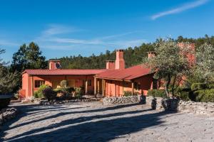 a house with a red roof on a dirt road at Hotel Barrancas del Cobre a Balderrama Collection Hotel in Areponapuchi