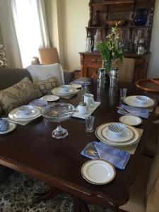 a dining room table with plates and dishes on it at Lulu's Bed & Breakfast in Niagara on the Lake