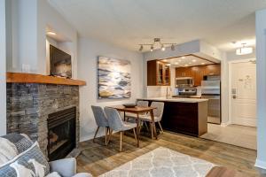 uma cozinha e sala de estar com uma mesa e uma lareira em Marquise by Whistler Blackcomb Vacation Rentals em Whistler