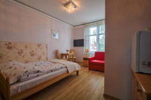 a bedroom with a bed and a red chair at Sopot Roza Apartments in Sopot