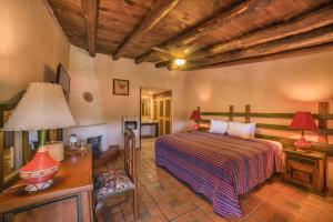 a bedroom with a bed and a table with a lamp at Hotel Barrancas del Cobre a Balderrama Collection Hotel in Areponapuchi