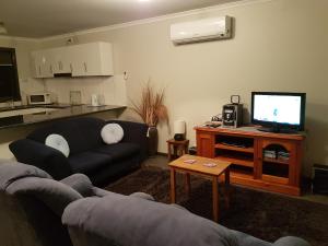 a living room with a couch and a flat screen tv at Wudinna Farm View in Wudinna