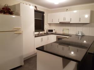 a kitchen with white cabinets and a white refrigerator at Wudinna Farm View in Wudinna