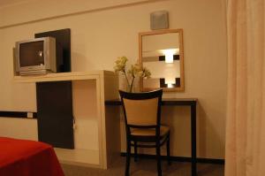 a room with a desk with a tv and a chair at Hotel Nuevo Mundo in San Rafael