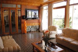 a living room with two couches and a tv at Hotel San Felipe el Real in San Felipe