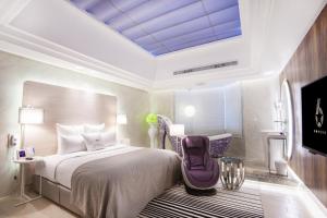 桃園區的住宿－六星-桃園館，一间卧室配有一张大床和紫色椅子