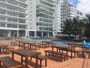 通苏帕Departamentos frente al mar en Resort Playa Azul-Tonsupa的楼前一排木桌和长椅