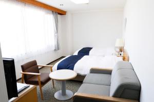 um quarto com uma cama, um sofá e uma secretária em Gran Hotel em Shingu