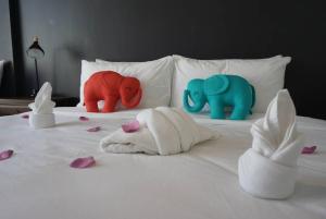 a bed with three stuffed elephants and flowers on it at PUNSUK@PRASING in Chiang Mai