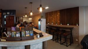 a bar in a restaurant with a woman sitting at a counter at PUNSUK@PRASING in Chiang Mai