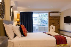 - une chambre avec un grand lit recouvert d'un cygne dans l'établissement Suan Dok Gate Guesthouse, à Chiang Mai