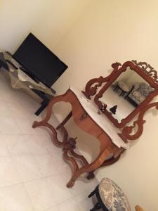 モーディカにあるAppartamento Sacro Cuoreの鏡付き木製テーブル、テレビ付