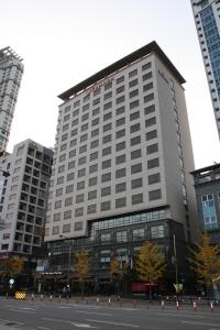 a tall building with many windows on a city street at Ramada by Wyndham Dongtan in Hwaseong