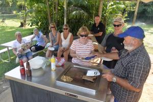 a group of people sitting around a table cooking food at BIG4 Howard Springs Holiday Park in Darwin