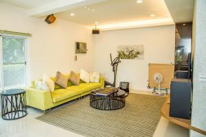ein Wohnzimmer mit einem gelben Sofa und einem Tisch in der Unterkunft Mountain Homestay 6-8人包棟民宿 in Xinhua