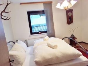 1 dormitorio con 2 almohadas blancas y ventana en 3 Sterne Ferienwohnungen Wachter, en Bischofsgrün