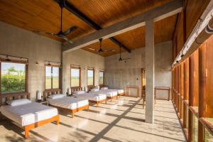 fila de camas en una habitación con ventanas en Tree Tops Yala, en Yala