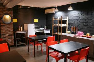 a restaurant with tables and red chairs and a kitchen at ZIP Hotel in Seoul