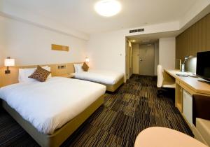 Daiwa Roynet Hotel Osaka-Uehonmachi tesisinde bir odada yatak veya yataklar
