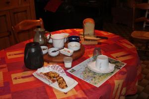 una mesa con un mantel rojo con comida. en Une Chambre D'Hote Yvetot, en Yvetot