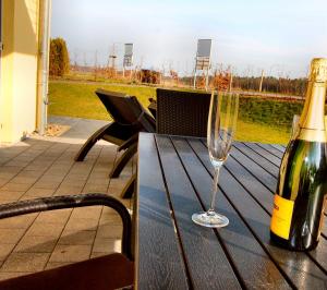 ゲーレン・レビンにあるHAUS TRAKEHNEN _EG_Fewoのワイン1本とワイングラス1杯(テーブルの上)