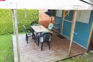 a wooden deck with a table and chairs on it at Haus STRANDLAeUFER _ EG_Fewo in Göhren-Lebbin