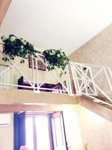 ナポリにあるSuite Orchidea by Dimorraの鉢植えの植物2本が植えられたバルコニー付きの客室です。