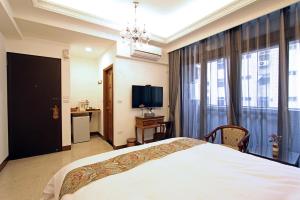 sypialnia z dużym łóżkiem i telewizorem w obiekcie Tuscany Homestay w mieście Hualian