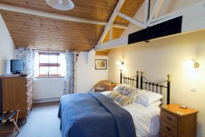 a bedroom with a bed with a blue blanket at Dairy Barns in Hickling