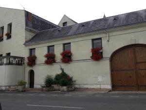 un edificio blanco con flores a un lado en le prieuré en Montsoreau