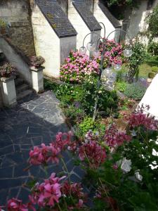 a garden with pink flowers and a staircase at le prieuré in Montsoreau