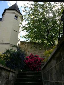 una escalera que conduce a un edificio con flores rosas en le prieuré en Montsoreau