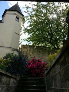 una escalera que conduce a un edificio con flores rosas en le prieuré, en Montsoreau