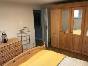 een slaapkamer met een houten bed en een dressoir bij Fewo Am Leegen Berg in Xanten